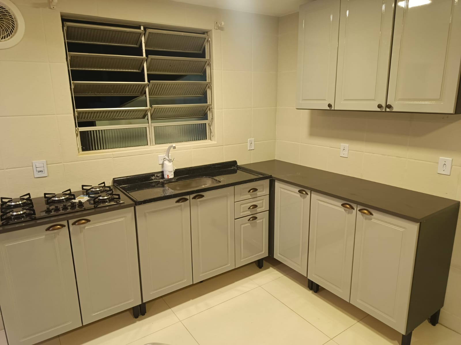 Cozinha modulada com balcão e armários aéreos